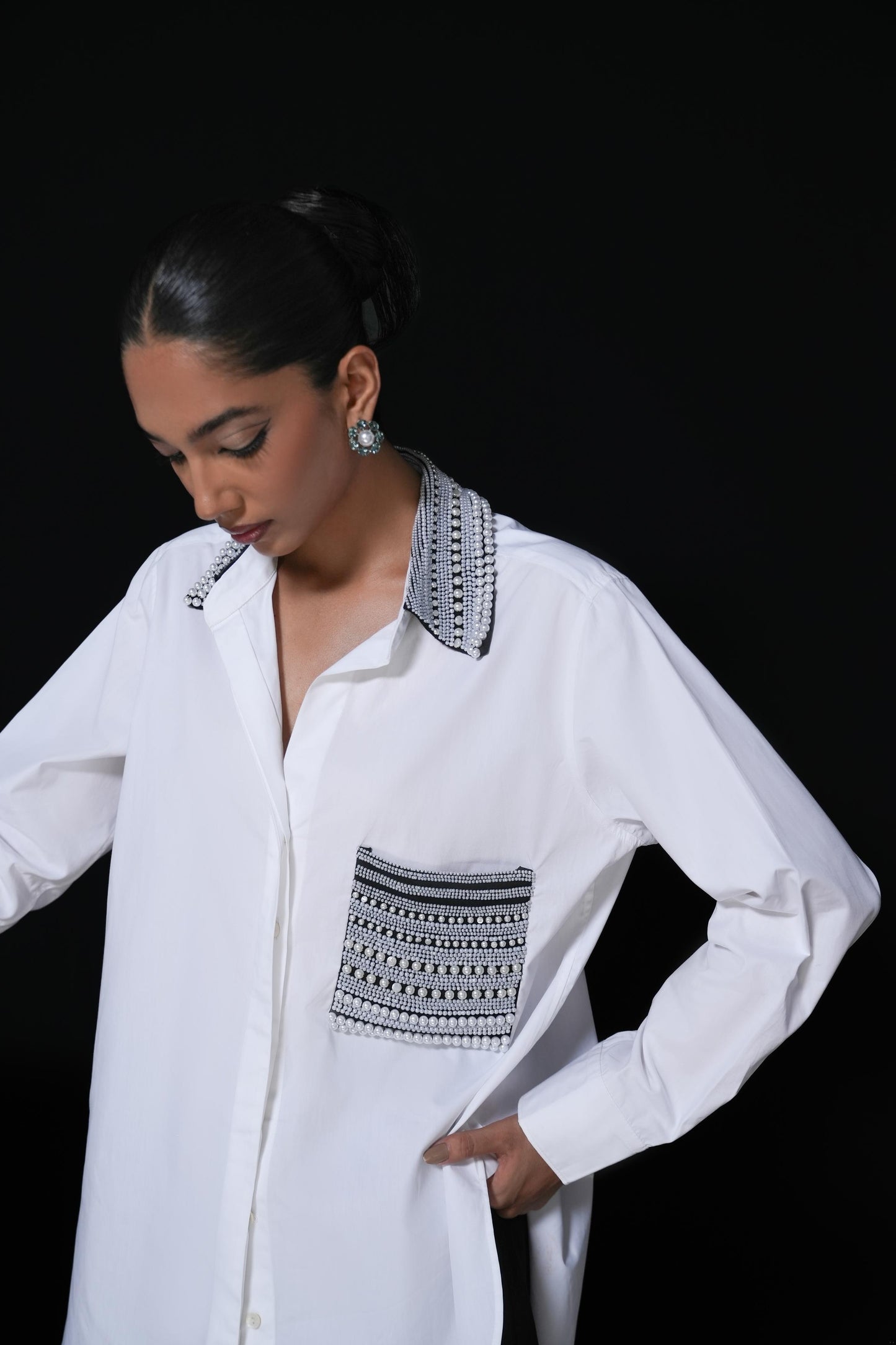 White cotton shirt with pearl detailing on pocket and collar paired with black trousers