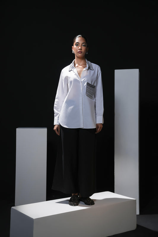 White cotton shirt with pearl detailing on pocket and collar paired with black trousers