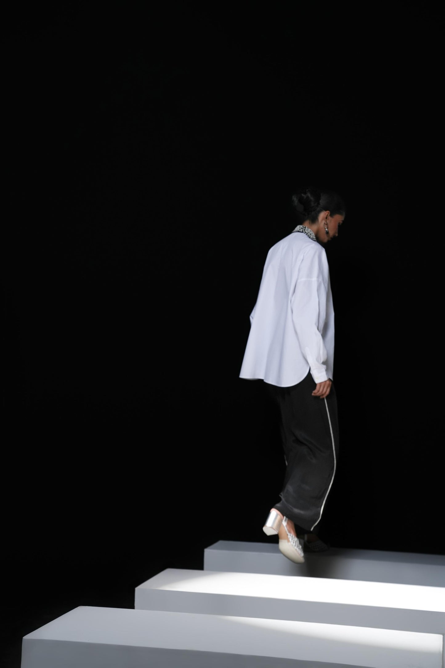 White cotton shirt with pearl detailing on pocket and collar paired with black trousers