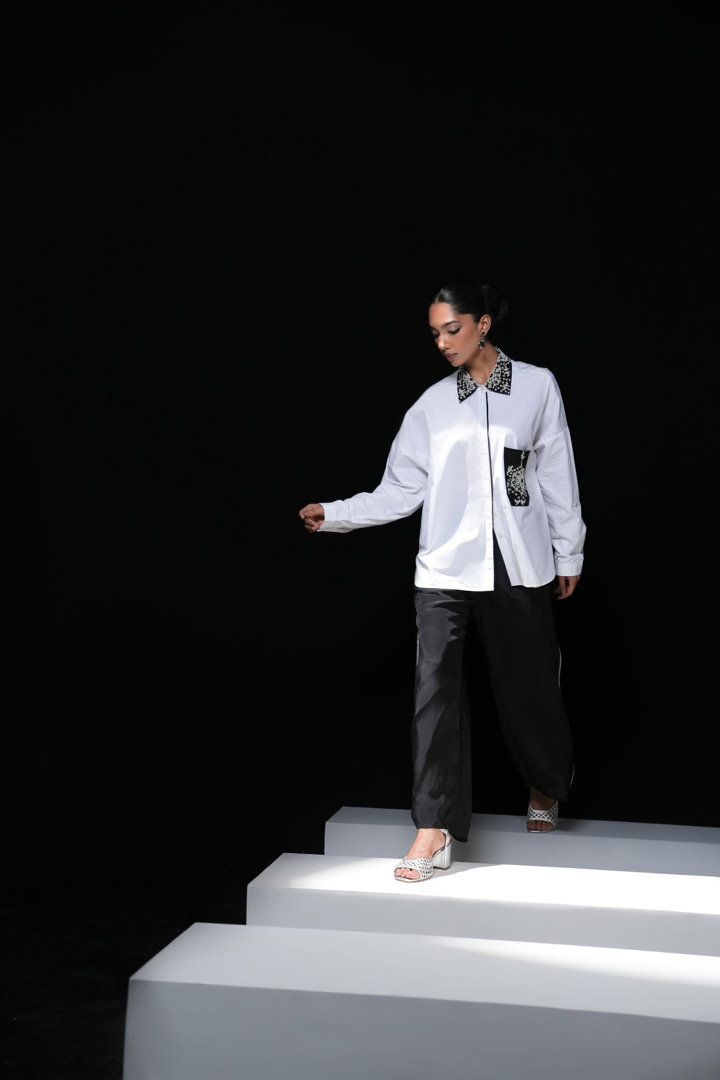 White cotton shirt with pearl detailing on pocket and collar paired with black trousers